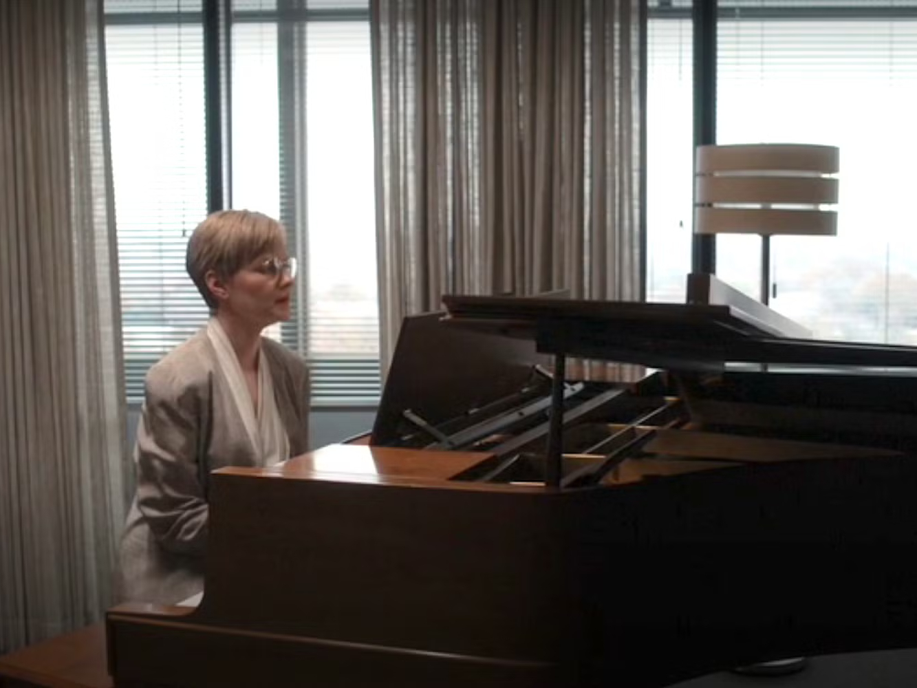 Margo Madison plays the piano in her office in For All Mankind